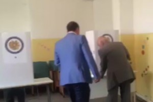 Председатель комиссии подходит к находящемуся в кабине для голосования избирателю